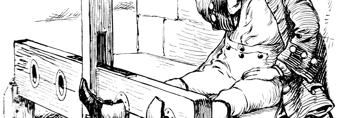 a man with his feet in the stocks