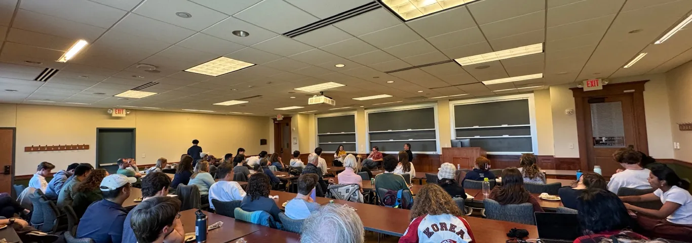 a room full of people listening to speakers
